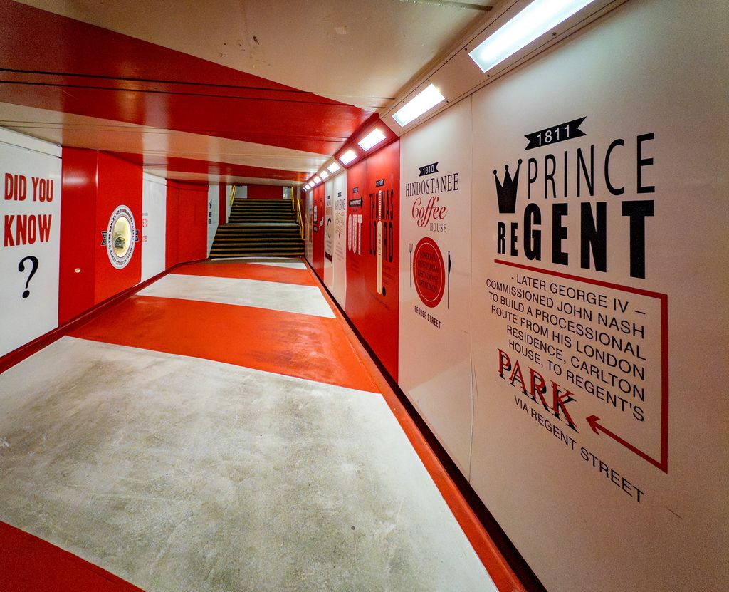 Vibrant indoor walkway with historical London signage, located in a tunnel at Marylebone Station.