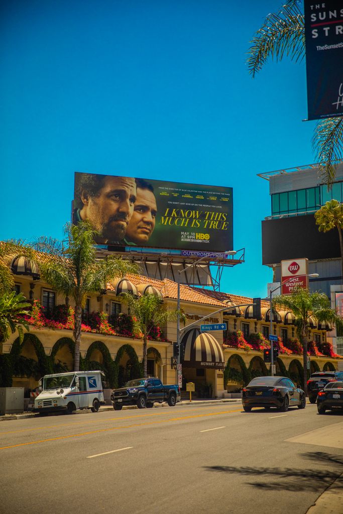Vibrant street view of Los Angeles with cars, buildings, and a prominent billboard.