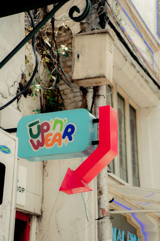 Vibrant 'Up'n' Wear' sign on a street in West Java, Indonesia. Ideal for tourism and city exploration themes.